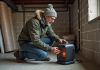 Chauffer un sous-sol non fini en hiver : avantages et conseils pratiques Homme inspectant un chauffage portable dans un sous-sol en travaux