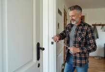 Homme posant un capteur sur une porte d'entrée moderne